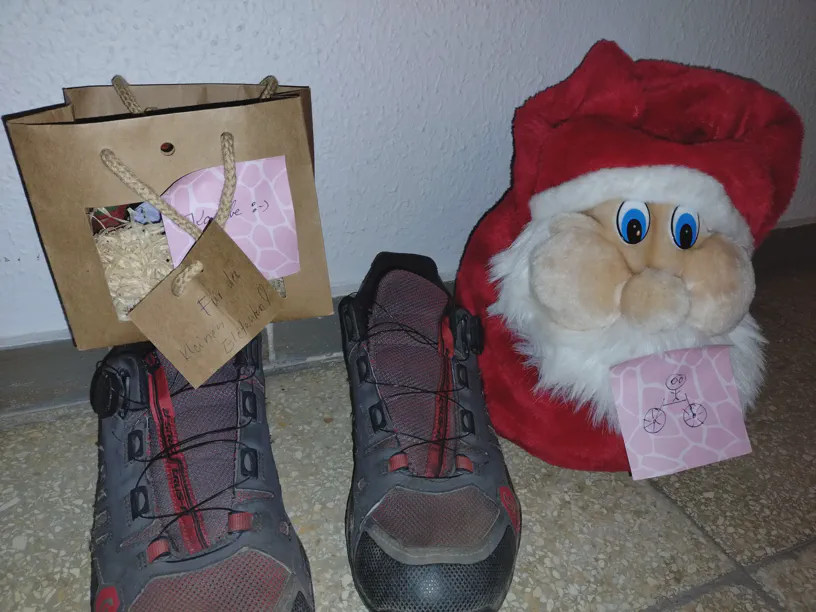 Ein paar Schuhe. Links auf dem Schuh ein Geschenkkarton fÃ¼r Kagube, rechts vom rechten Schuh steht ein Beutel in Form eines Nikolausgesitzts auf dem Boden.
